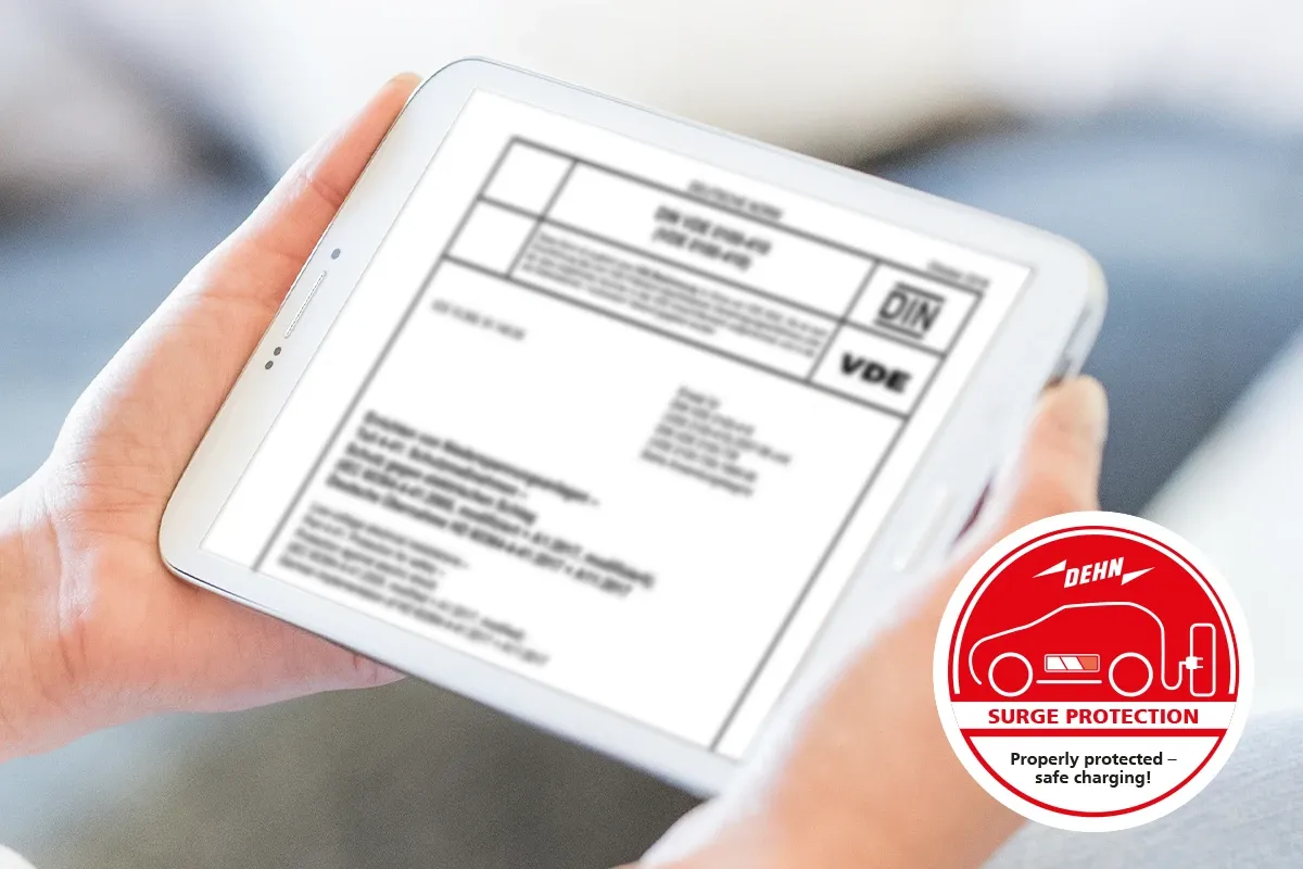 Tablet displaying DIN and VDE standards document with DEHN surge protection safe charging badge
