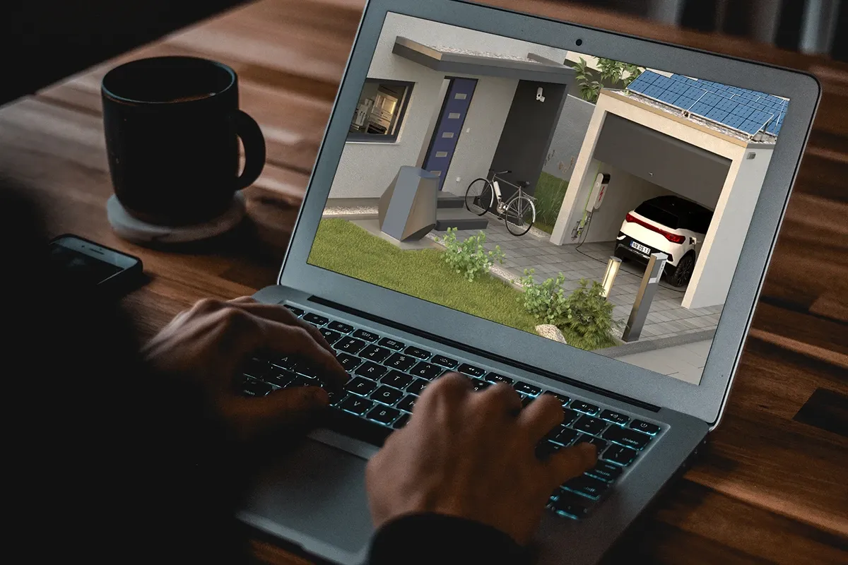 Person using laptop showing house with solar panels, EV charger and wallbox in garage